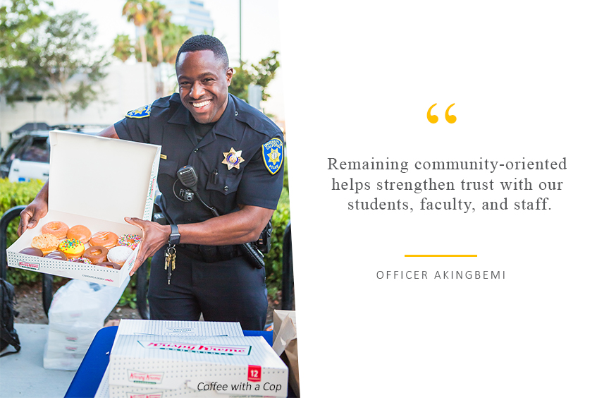 Officer Akingbemi holding up donuts and smiling