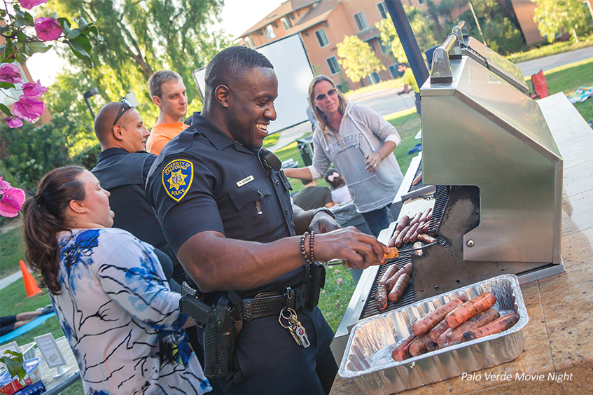 Officer Akingbemi cooking hot dogs and burgers at Palo Verde Movie Night